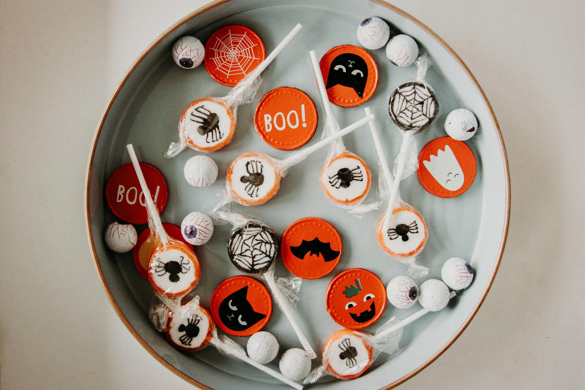 Halloween themed foil wrapped chocolates and suckers in a round serving tray